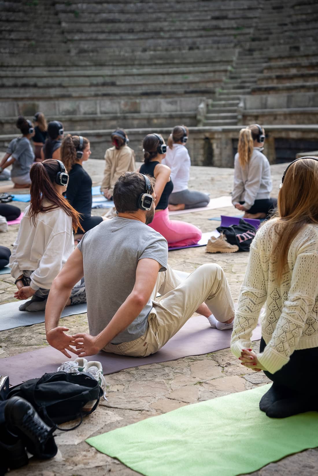 A yoga class in AURA headphones outdoors