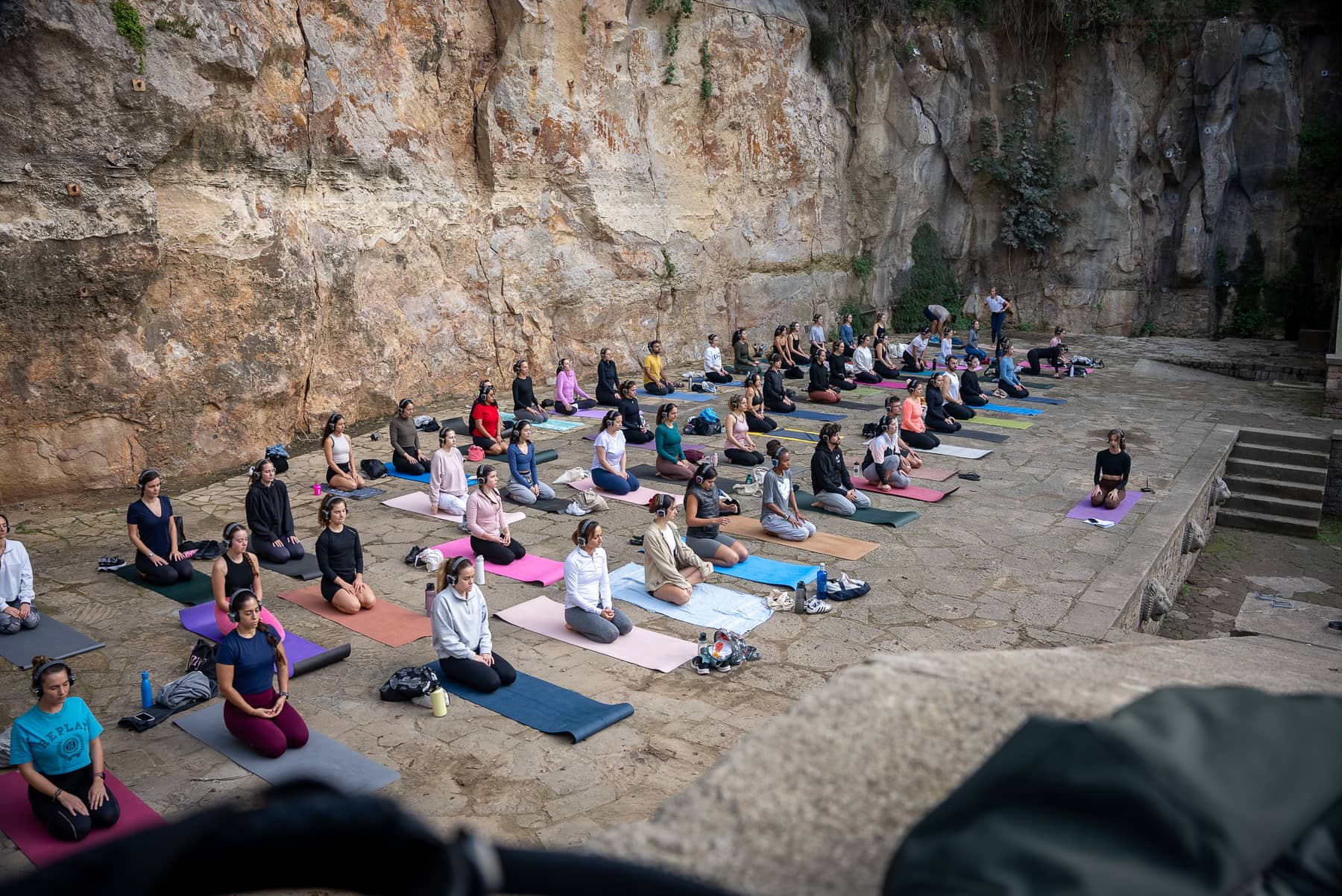 People meditating in AURA headphones in a Barcelona stone quarry